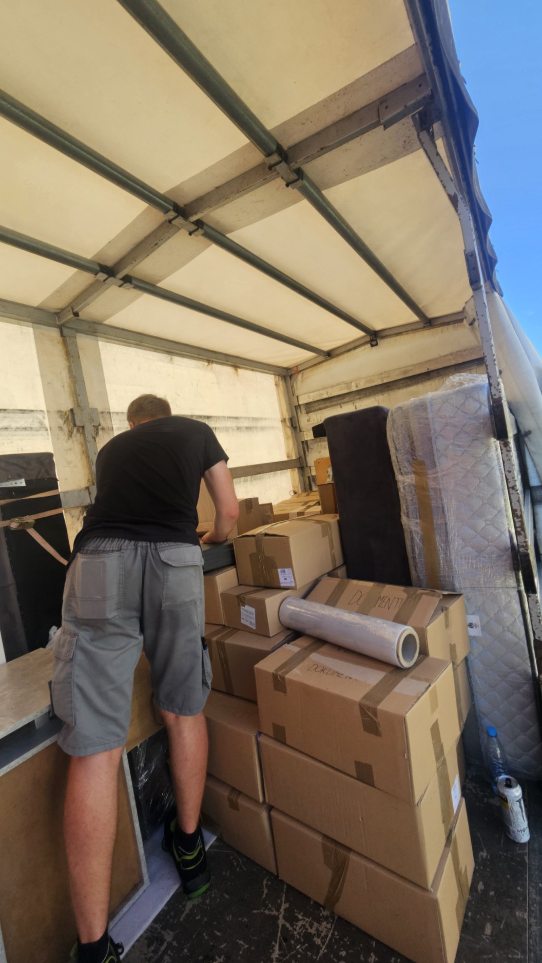 Delavec LLogistike nalaga škatle v kombi med selitvijo